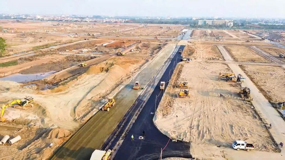 Cận cảnh một đoạn đường đang được trải nhựa tại dự án Vinhomes Đan Phượng, nhiều máy móc thi công xung quanh